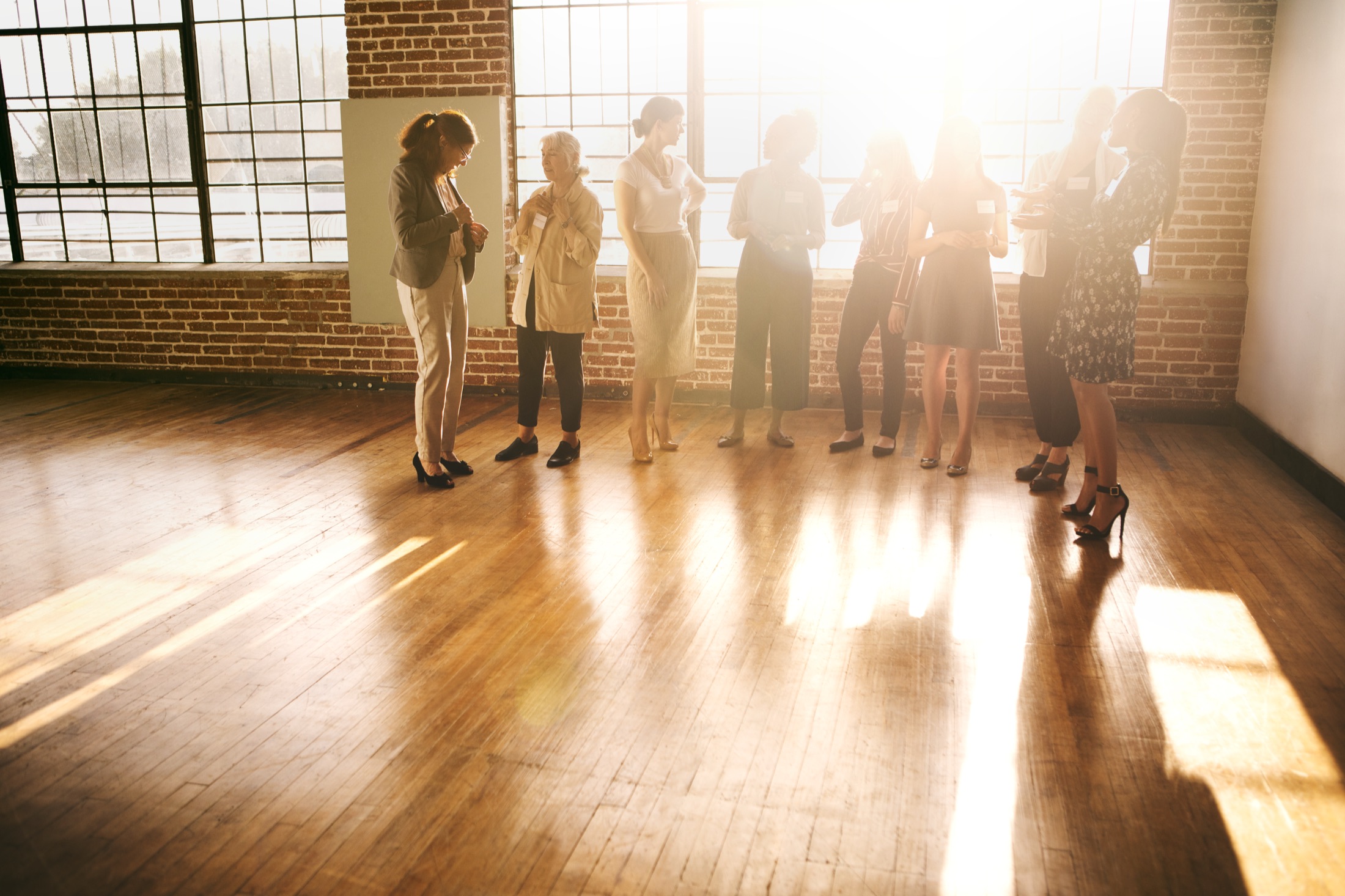 A workshop group gathered in a bright, sunlit room